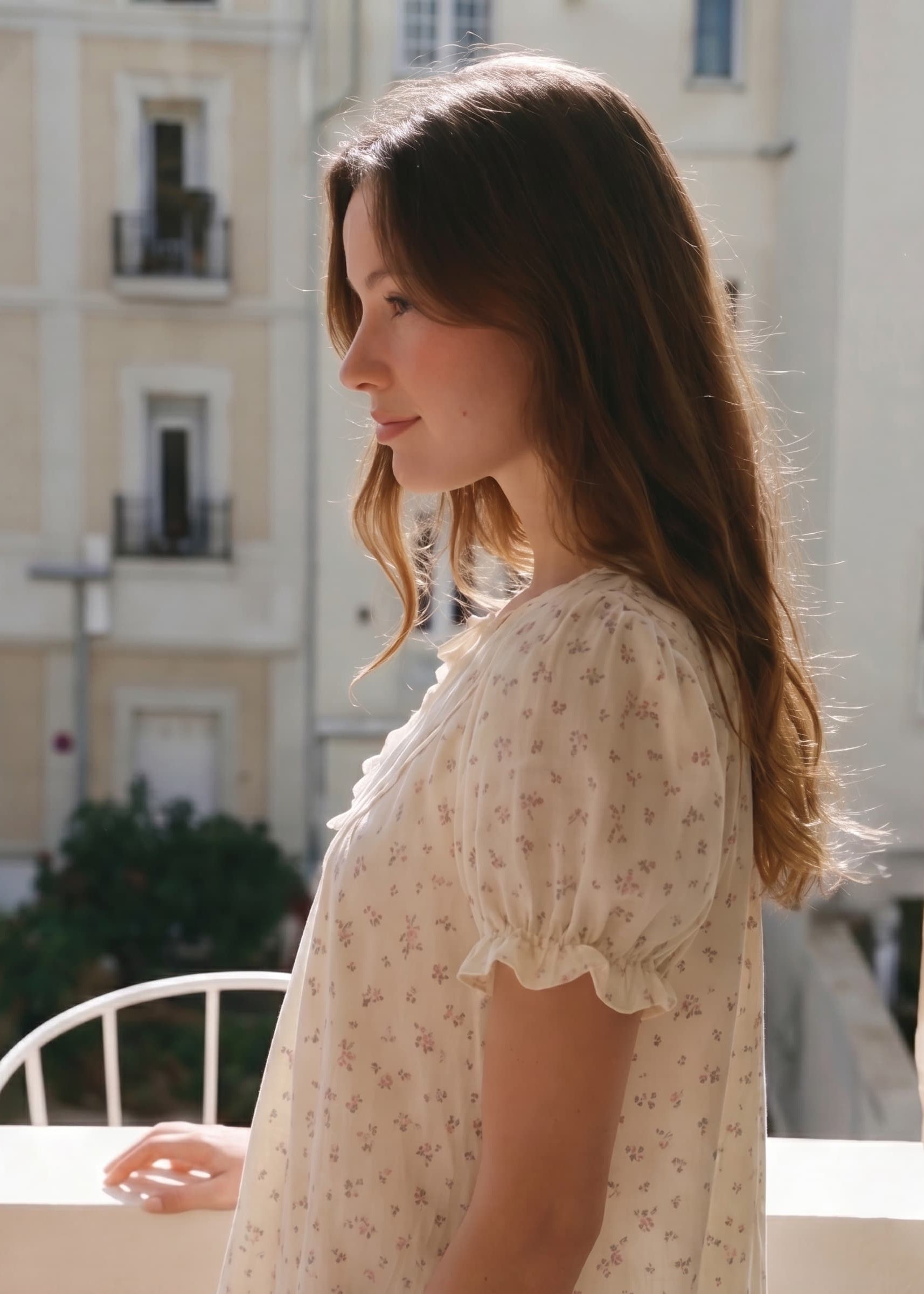 Woman in a floral blouse standing on a balcony with buildings in the background