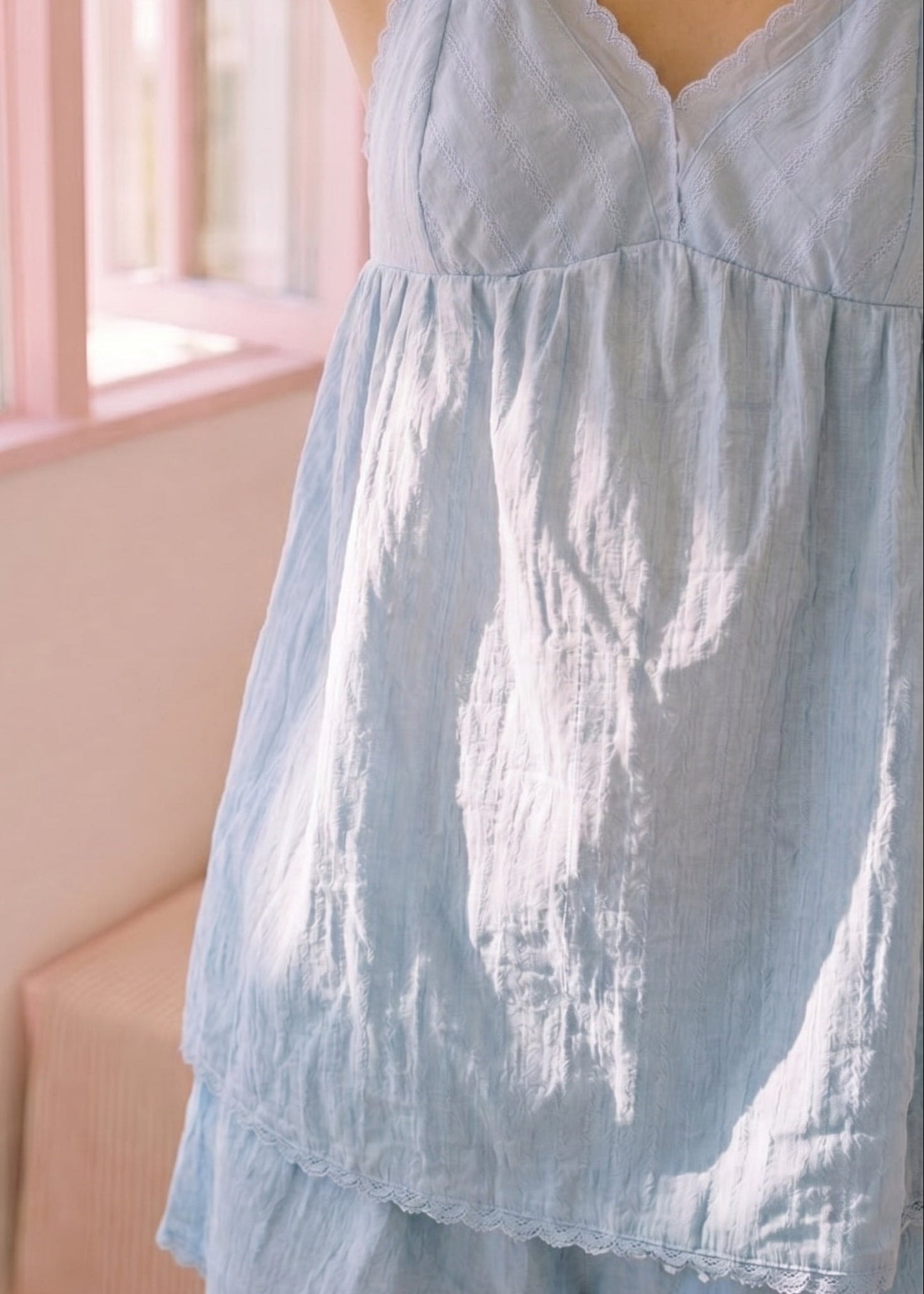Light blue dress worn by a person in a softly blurred indoor setting